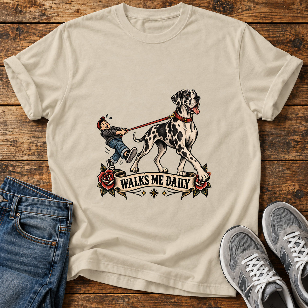 Walks Me Daily Great Dane graphic T-shirt in Sand, shown on a flat-lay shirt mockup