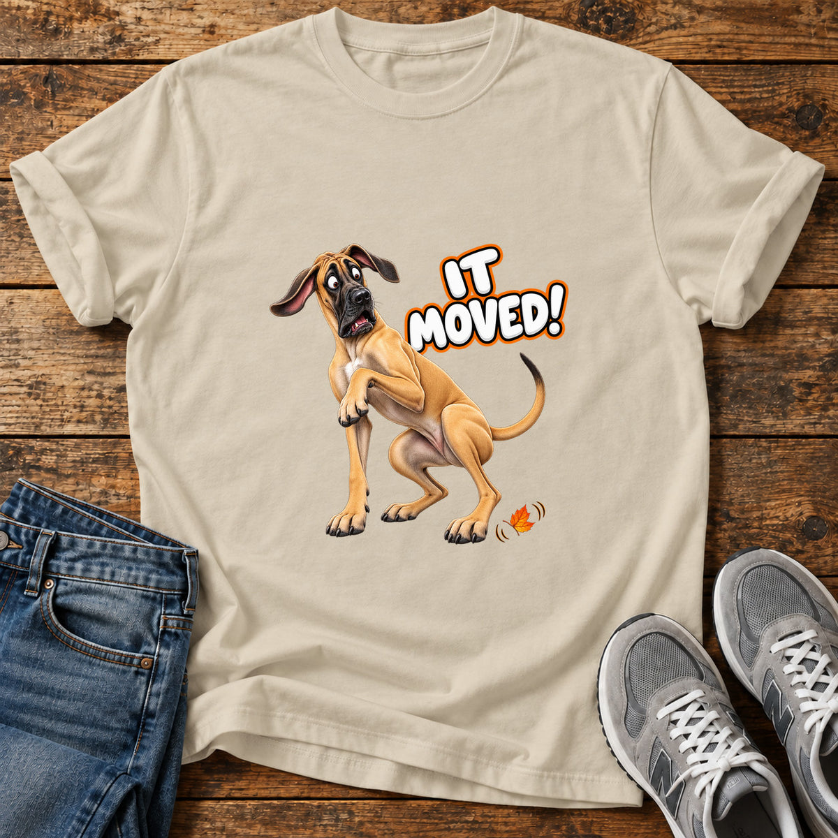 It Moved Great Dane graphic T-shirt in Sand, shown on a flat-lay shirt mockup