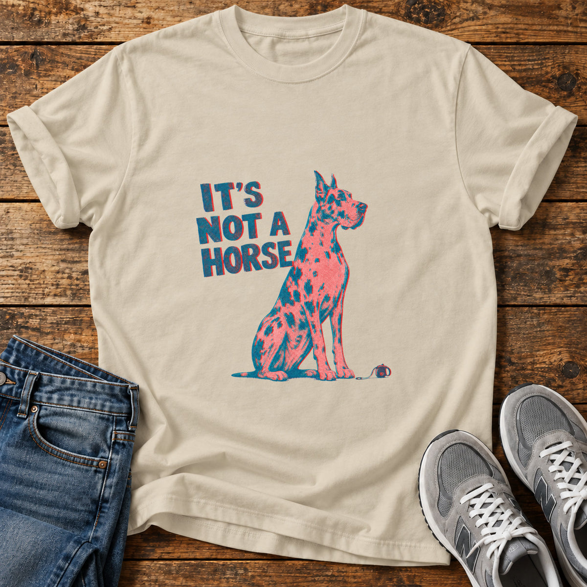 It's Not A Great Dane graphic T-shirt in Sand, shown on a flat-lay shirt mockup