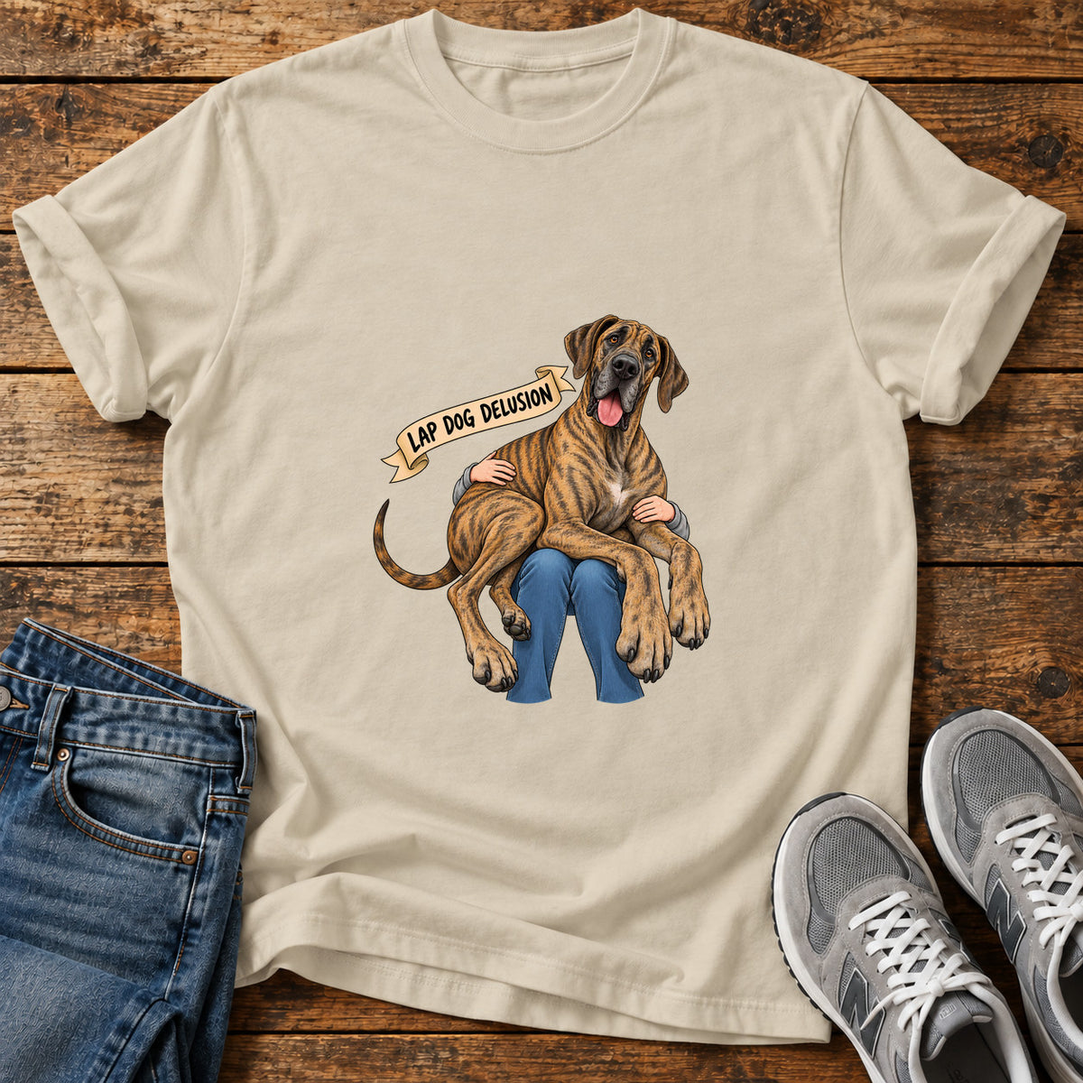 Lap Dog Delusion Great Dane graphic T-shirt in Sand, shown on a flat-lay shirt mockup
