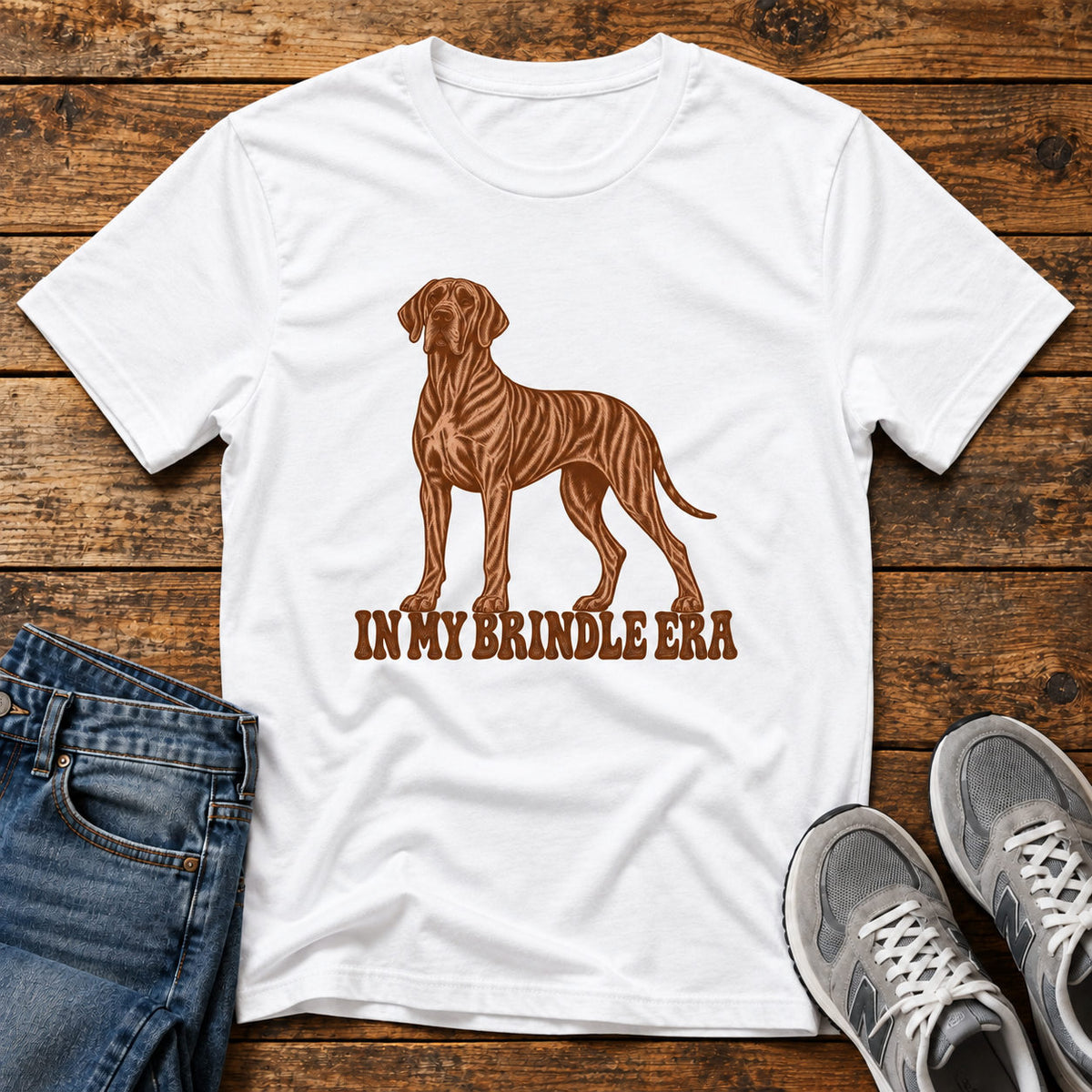 Brindle Era T-shirt on a light wood flat lay with jeans and walking shoes